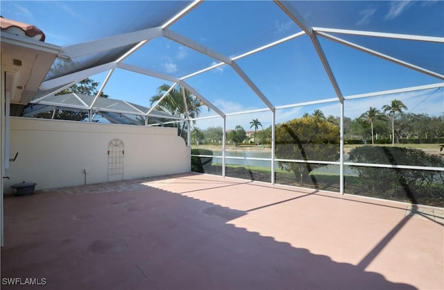 view of patio / terrace featuring a water view and glass enclosure