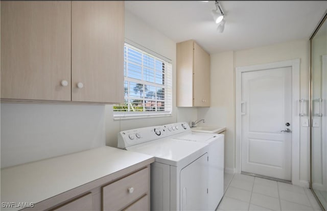 laundry area with sink, light tile patterned floors, cabinets, track lighting, and washing machine and clothes dryer