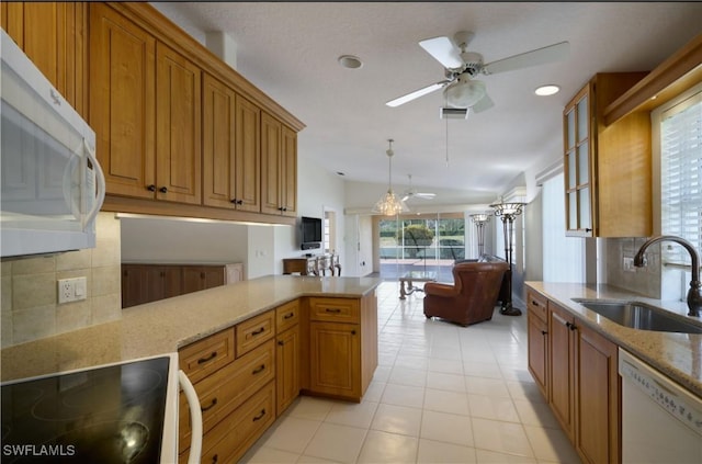 kitchen featuring light tile patterned flooring, sink, decorative light fixtures, kitchen peninsula, and white appliances