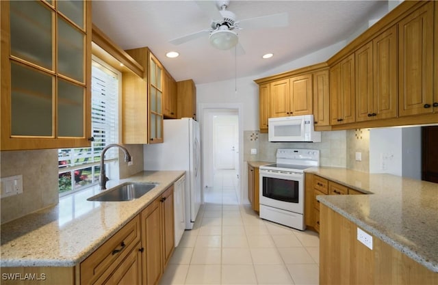 kitchen featuring sink, white appliances, light tile patterned floors, light stone counters, and decorative backsplash