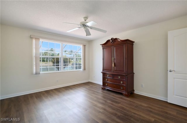 spare room with a textured ceiling, dark wood-type flooring, and ceiling fan