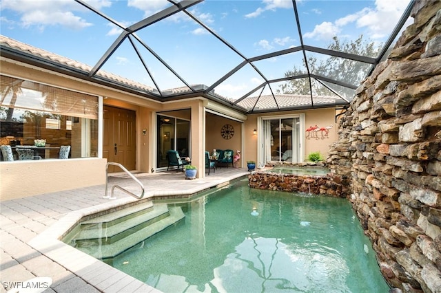 view of pool with an in ground hot tub, a patio, and glass enclosure