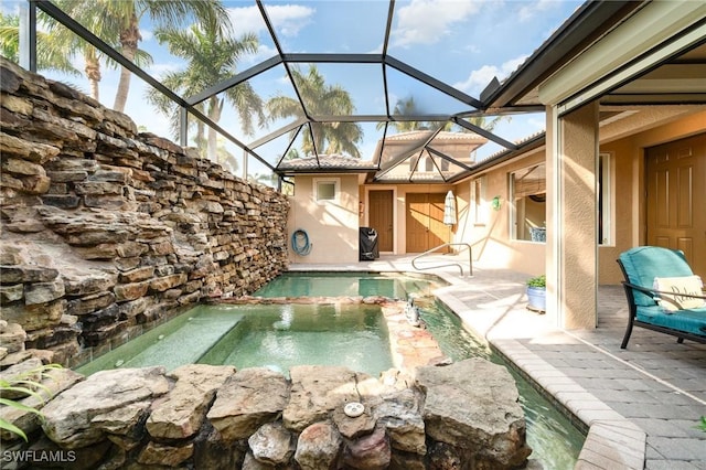 view of pool featuring glass enclosure and a patio area