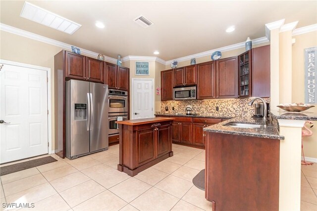 kitchen with stainless steel appliances, light tile patterned flooring, sink, and decorative backsplash