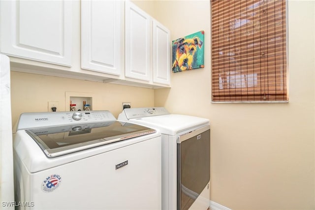 washroom featuring cabinets and washer and clothes dryer