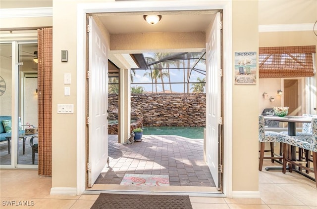 doorway featuring light tile patterned flooring and crown molding