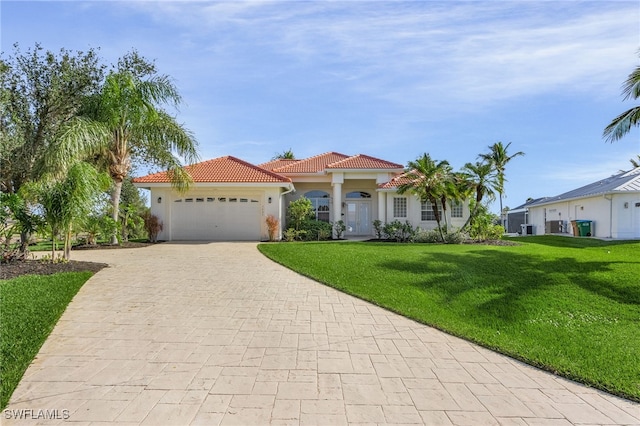 mediterranean / spanish-style home featuring a garage and a front lawn