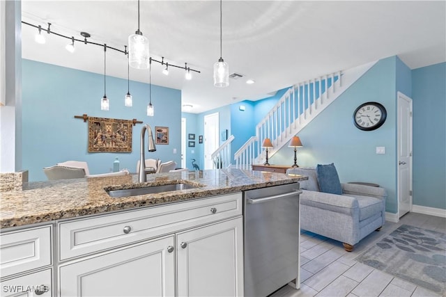 kitchen with stone counters, white cabinetry, sink, dishwasher, and decorative light fixtures