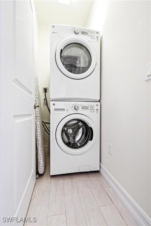 washroom featuring stacked washing maching and dryer