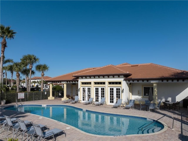 view of swimming pool with french doors and a patio