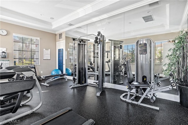 gym with a raised ceiling and ornamental molding