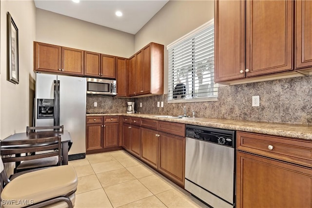 kitchen featuring decorative backsplash, appliances with stainless steel finishes, light tile patterned floors, and sink