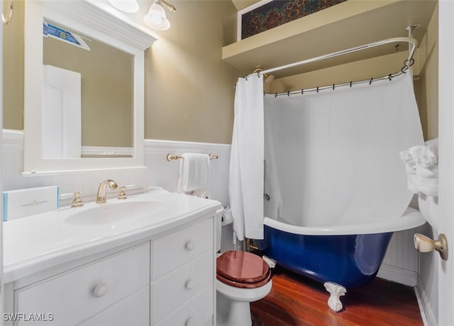 full bathroom with hardwood / wood-style floors, vanity, shower / tub combo, and toilet