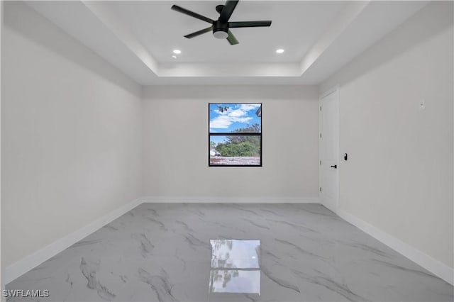 unfurnished room featuring ceiling fan and a tray ceiling