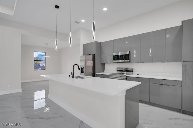 kitchen featuring appliances with stainless steel finishes, decorative light fixtures, gray cabinetry, and sink