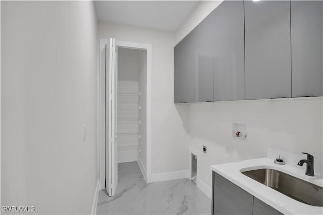 washroom featuring washer hookup, sink, cabinets, and hookup for an electric dryer