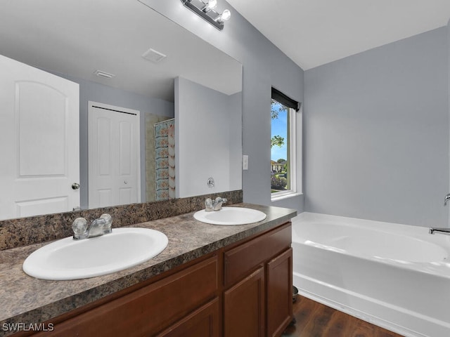 bathroom with hardwood / wood-style floors, vanity, and independent shower and bath