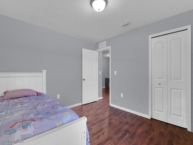 bedroom with dark hardwood / wood-style floors and a closet