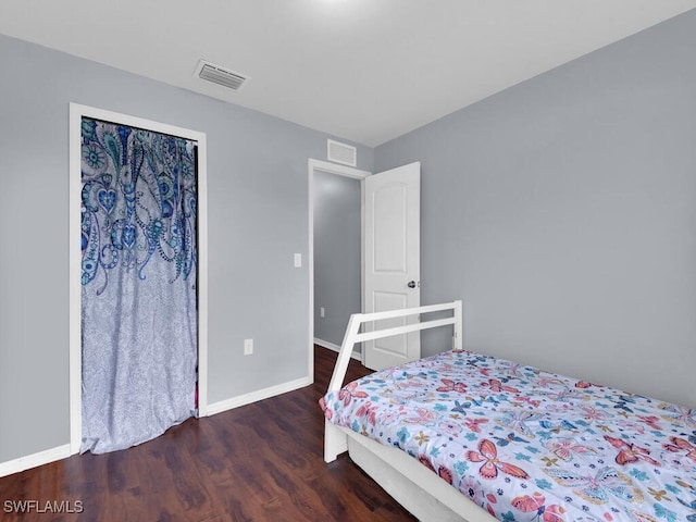 bedroom with dark wood-type flooring