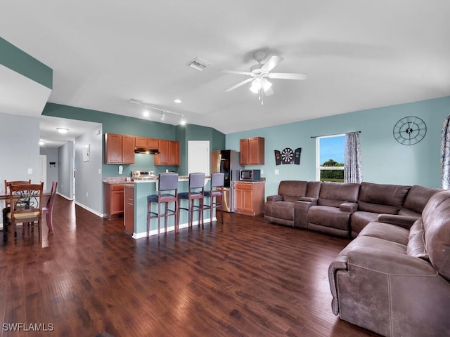 living room with ceiling fan, dark wood-type flooring, and lofted ceiling