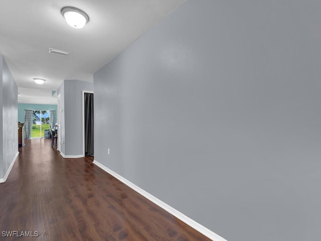 hallway with dark hardwood / wood-style flooring