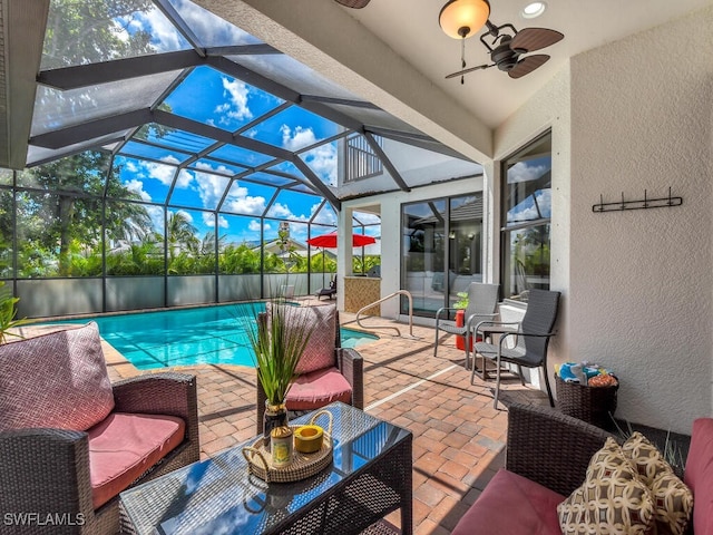 view of swimming pool featuring a fenced in pool, glass enclosure, ceiling fan, a patio area, and an outdoor living space