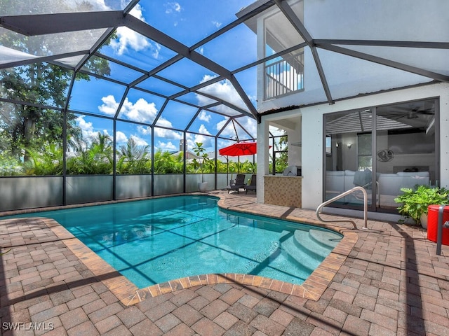 view of swimming pool with glass enclosure, a patio area, and a fenced in pool