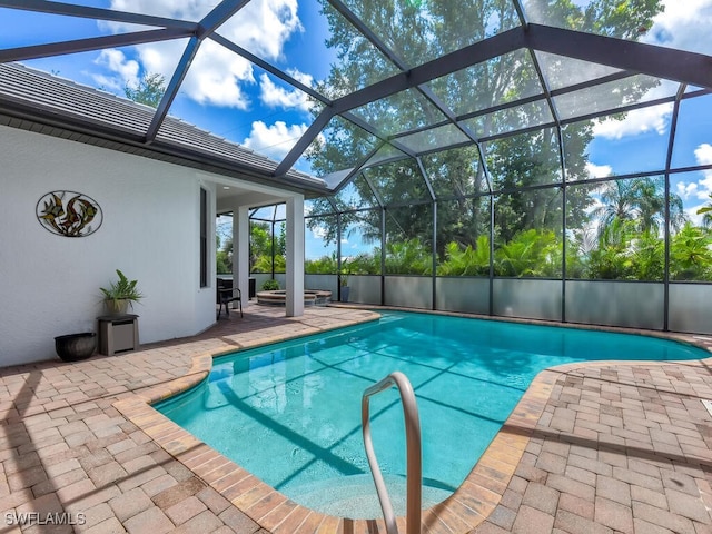 pool featuring a patio area and glass enclosure