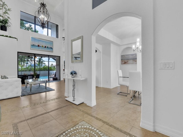 tiled entryway with a chandelier