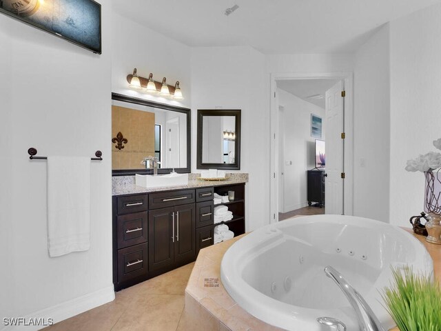 full bath with tile patterned flooring, a jetted tub, and vanity