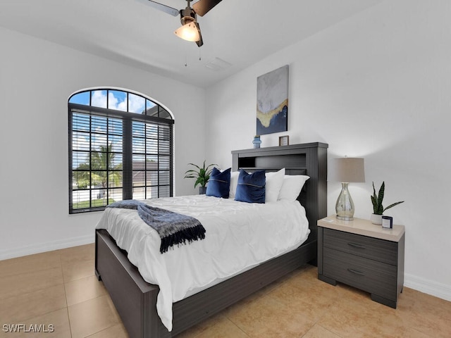 bedroom featuring light tile patterned floors, baseboards, and a ceiling fan