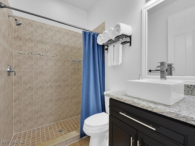 bathroom featuring toilet, a stall shower, tile patterned flooring, and vanity