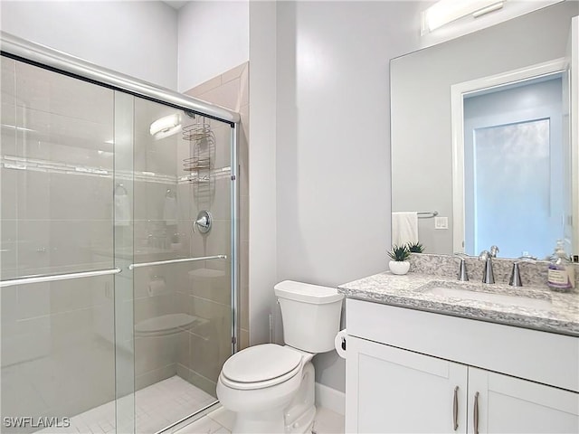 bathroom with a shower with door, toilet, and vanity