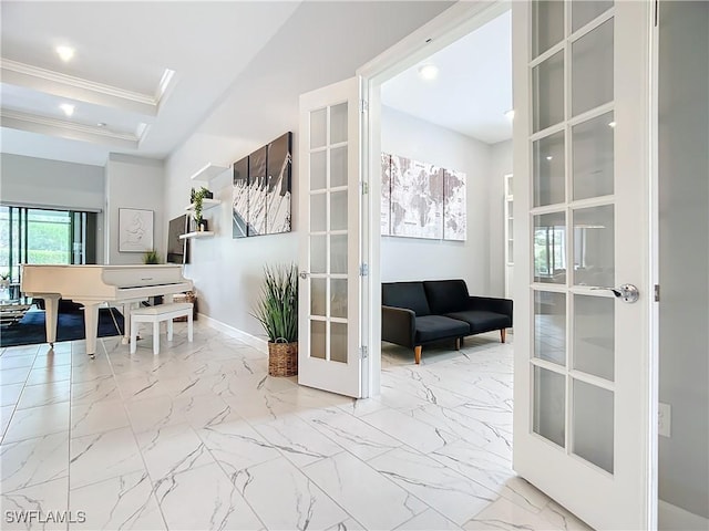 hall featuring a raised ceiling, ornamental molding, and french doors