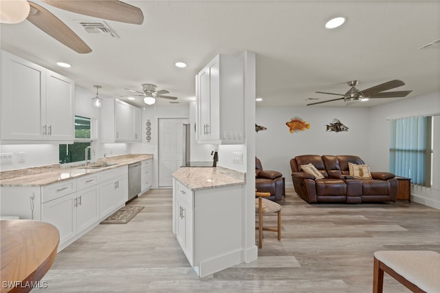 kitchen with dishwasher, white cabinetry, and light stone countertops