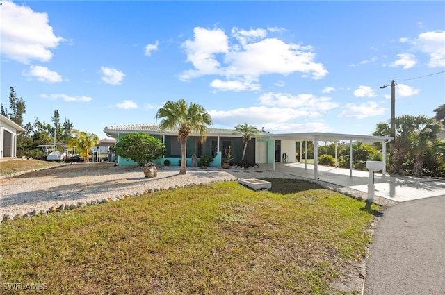 view of front of home with a carport and a front lawn