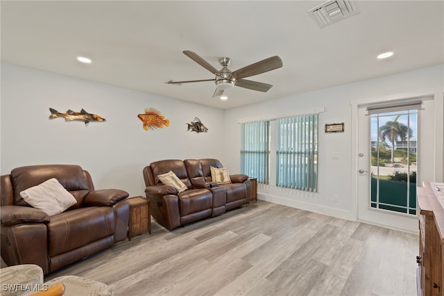 living room with light hardwood / wood-style flooring and ceiling fan