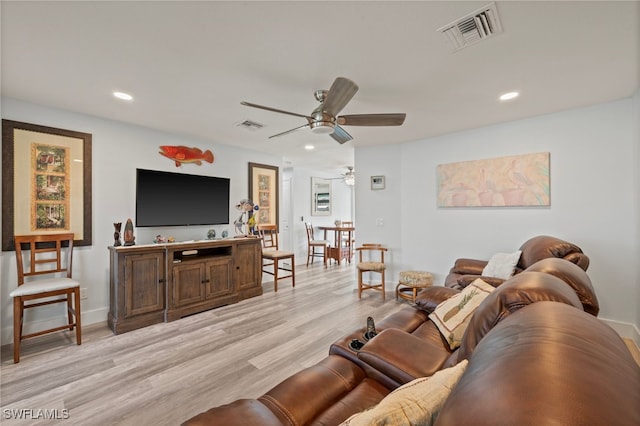 living room with ceiling fan and light hardwood / wood-style flooring