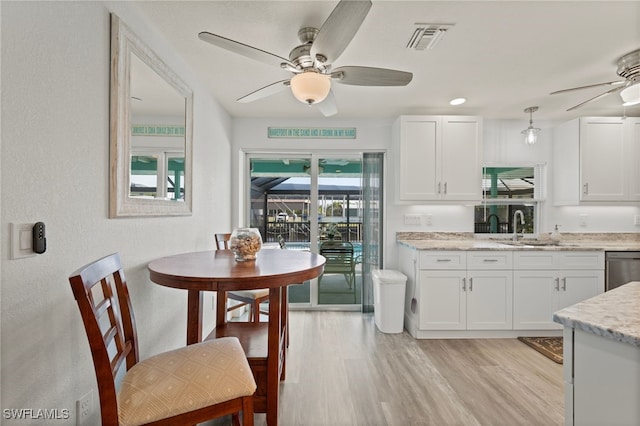 kitchen featuring dishwasher, sink, white cabinets, and light hardwood / wood-style flooring