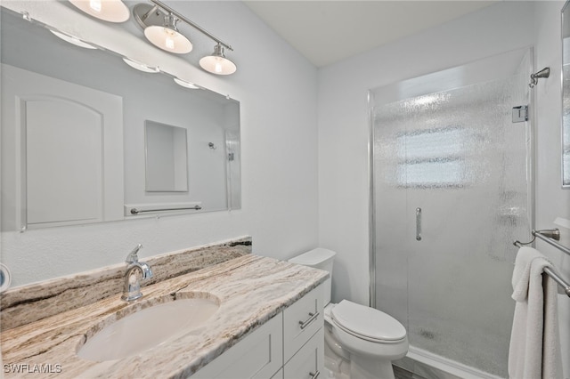 bathroom featuring vanity, toilet, and an enclosed shower