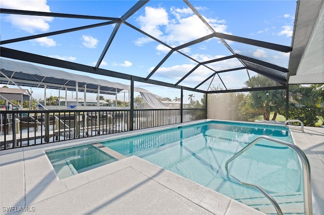 view of swimming pool with a water view, glass enclosure, and a patio area