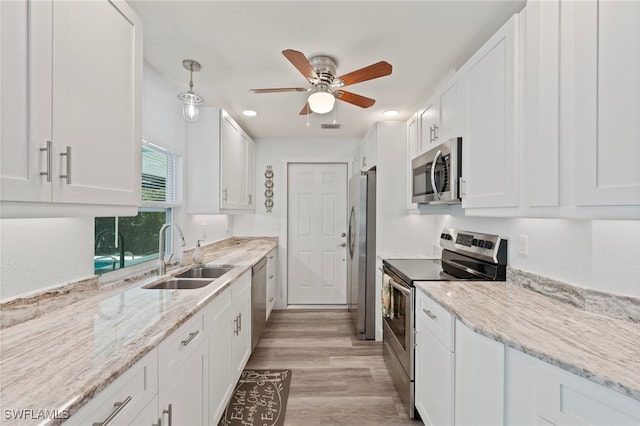 kitchen with white cabinetry, sink, light wood-type flooring, and appliances with stainless steel finishes