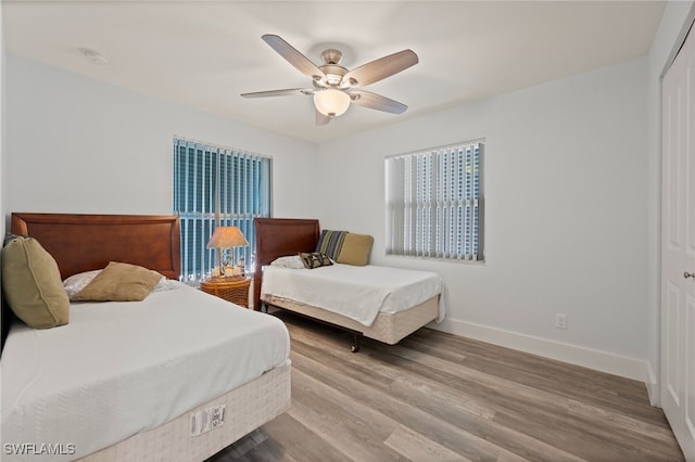 bedroom featuring ceiling fan, a closet, and hardwood / wood-style flooring