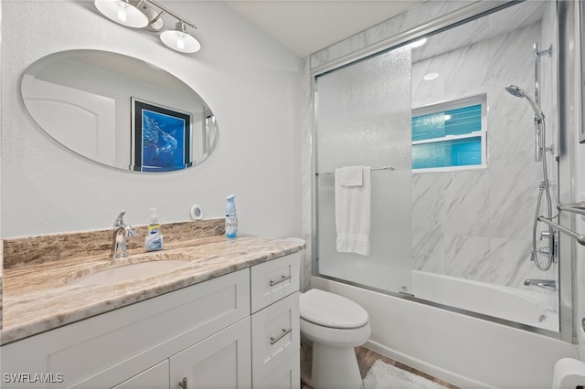 full bathroom featuring shower / bath combination with glass door, vanity, and toilet