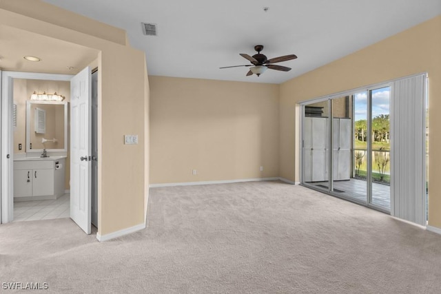 spare room with ceiling fan, sink, and light carpet