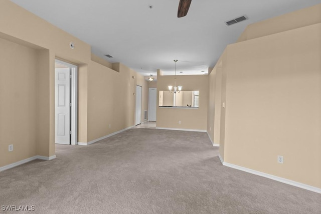 unfurnished living room featuring ceiling fan with notable chandelier and light colored carpet