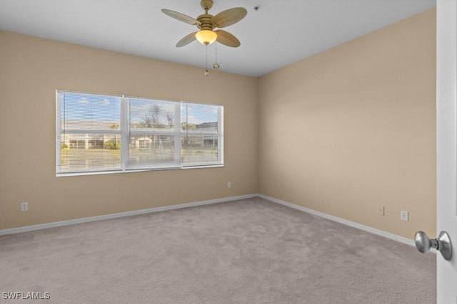 carpeted spare room with ceiling fan