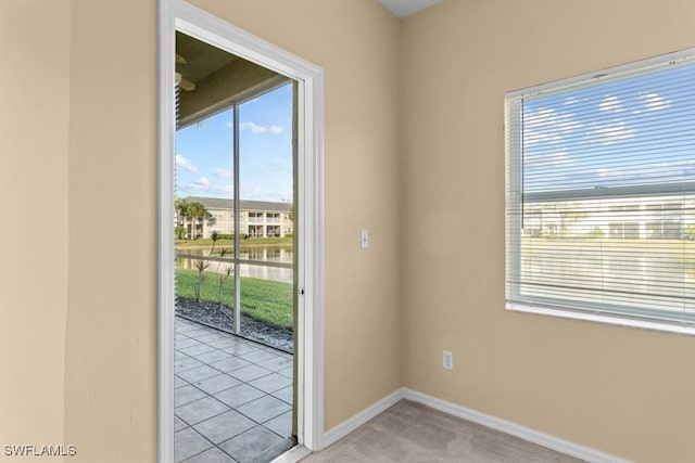 doorway to outside with a water view and light carpet