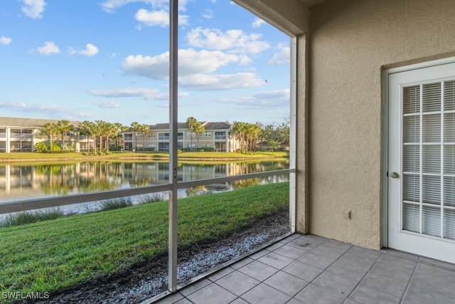 unfurnished sunroom featuring a water view