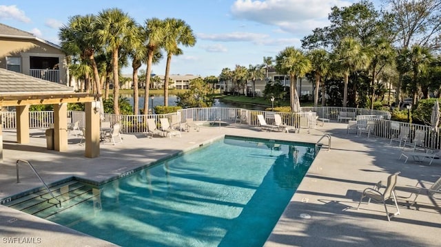 view of pool with a patio and a water view